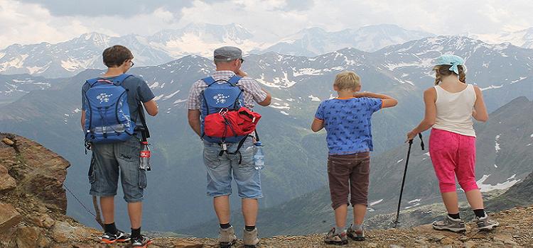 Drei Kinder und der Vater auf einem Wanderweg