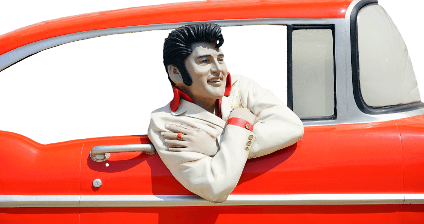 Elvis der King sitzt in einem roten Oldtimer