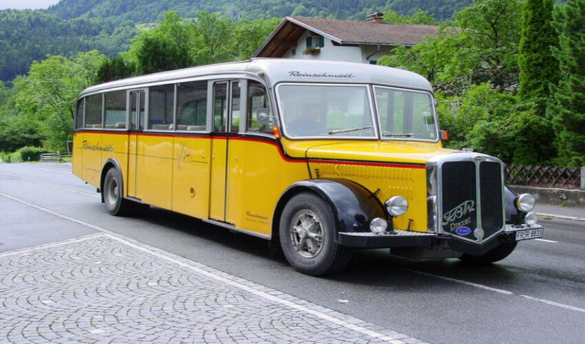 Ein gelber Oldtimer Bus mit hell grauem Dach.