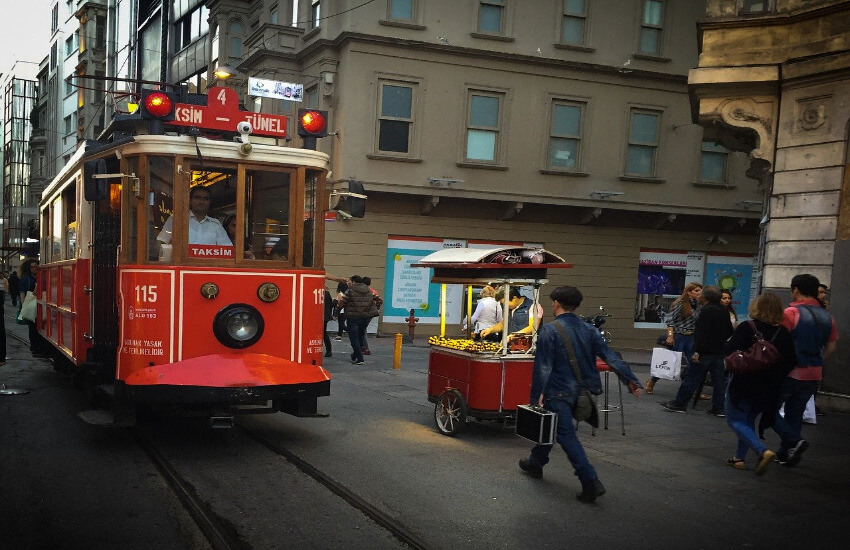 Eine Tram fährt durch eine enge Gasse.