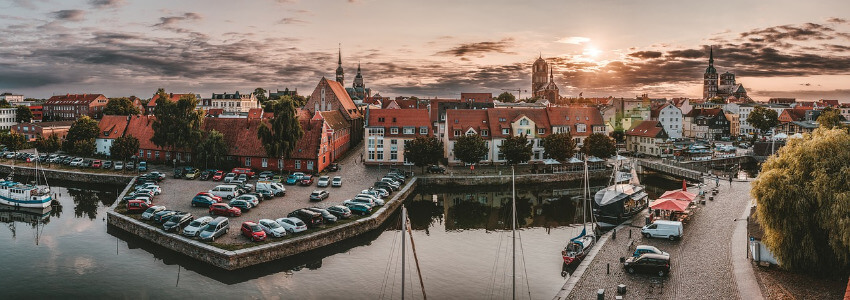 Der Hafen vom Stralsund während des Sonnenuntergangs mit der Altstadt im Hintergrund.