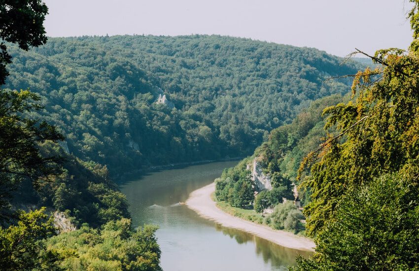 Mit Bäumen bewachsene Hügel, wo sich ein Fluss mit einer Kehre durchgeht.