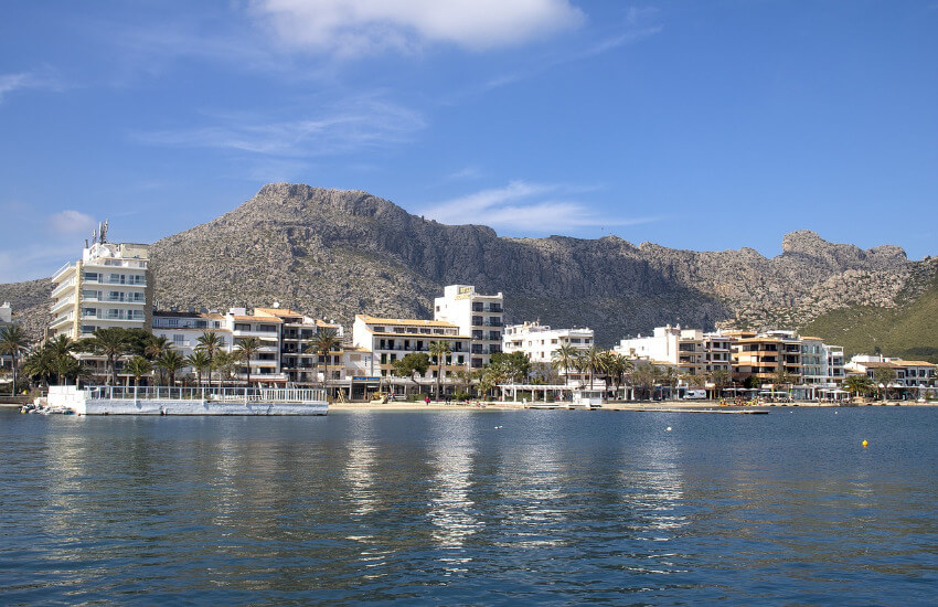 Einige weiß bemalte Hotels entlang der Küste vorm Strand von Pollenca.