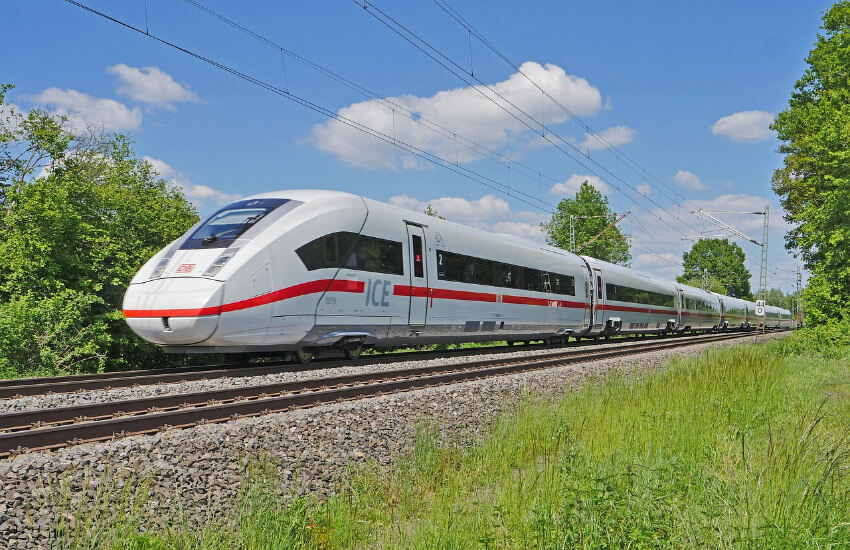 Ein ICE der Deutschen Bahn fährt durch eine unbewohnte Landschaft.