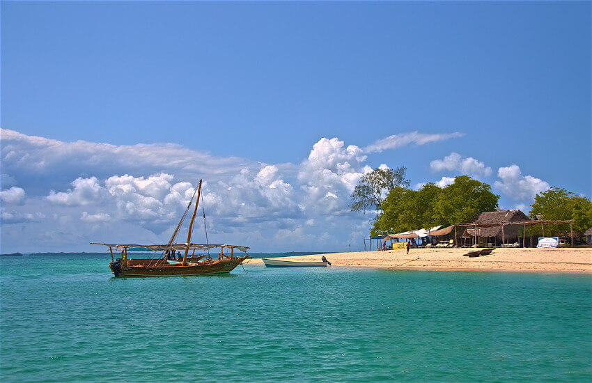 Ein Touristenboot, etwas abgelegen an einem Sandstrand.