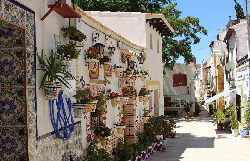 Kleine alte Häuser mit bunten Kacheln und Blumen geschmückt.