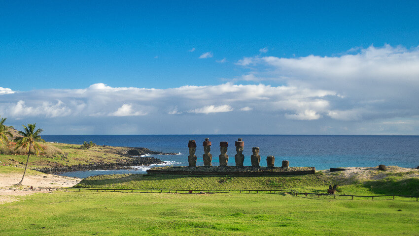 Mehrere Moai auf einer Anhöhe vor dem Meer.