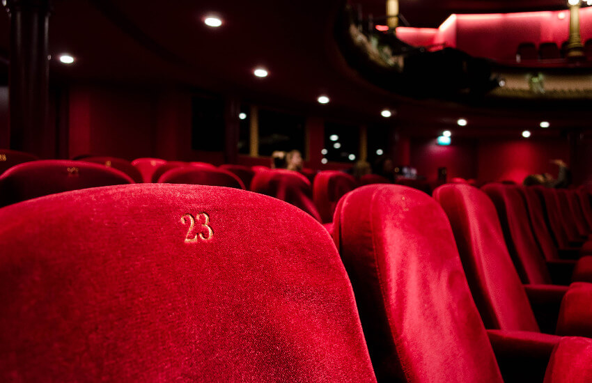 Ein Kinosaal mit roten Sesseln.