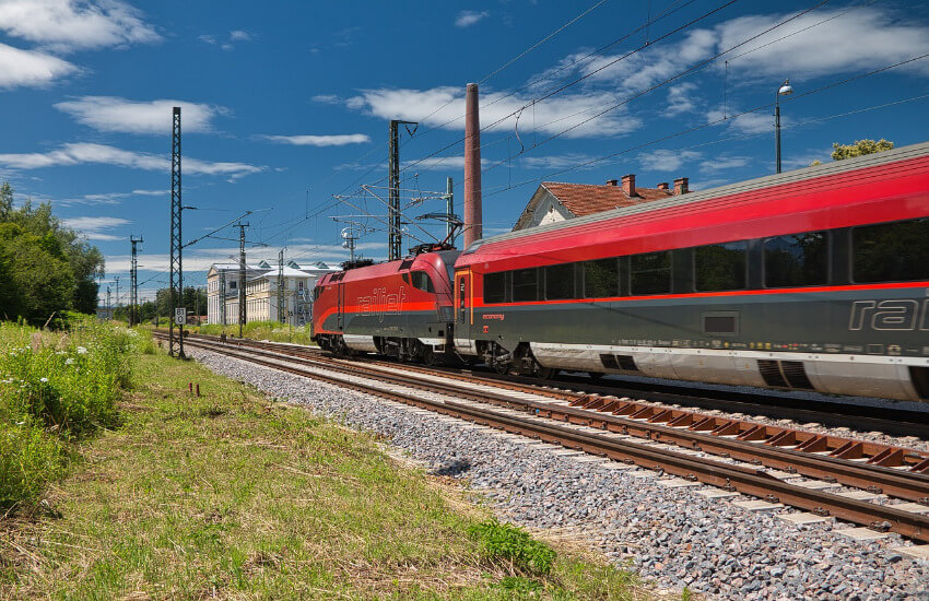 Ein roter Railjet der ÖBB fährt auf der Weststrecke.