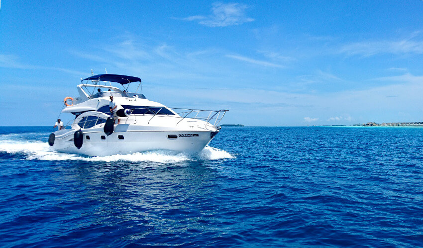Eine weiße Yacht fährt auf dem blauen Meer an einem traumhaften Sommertag.